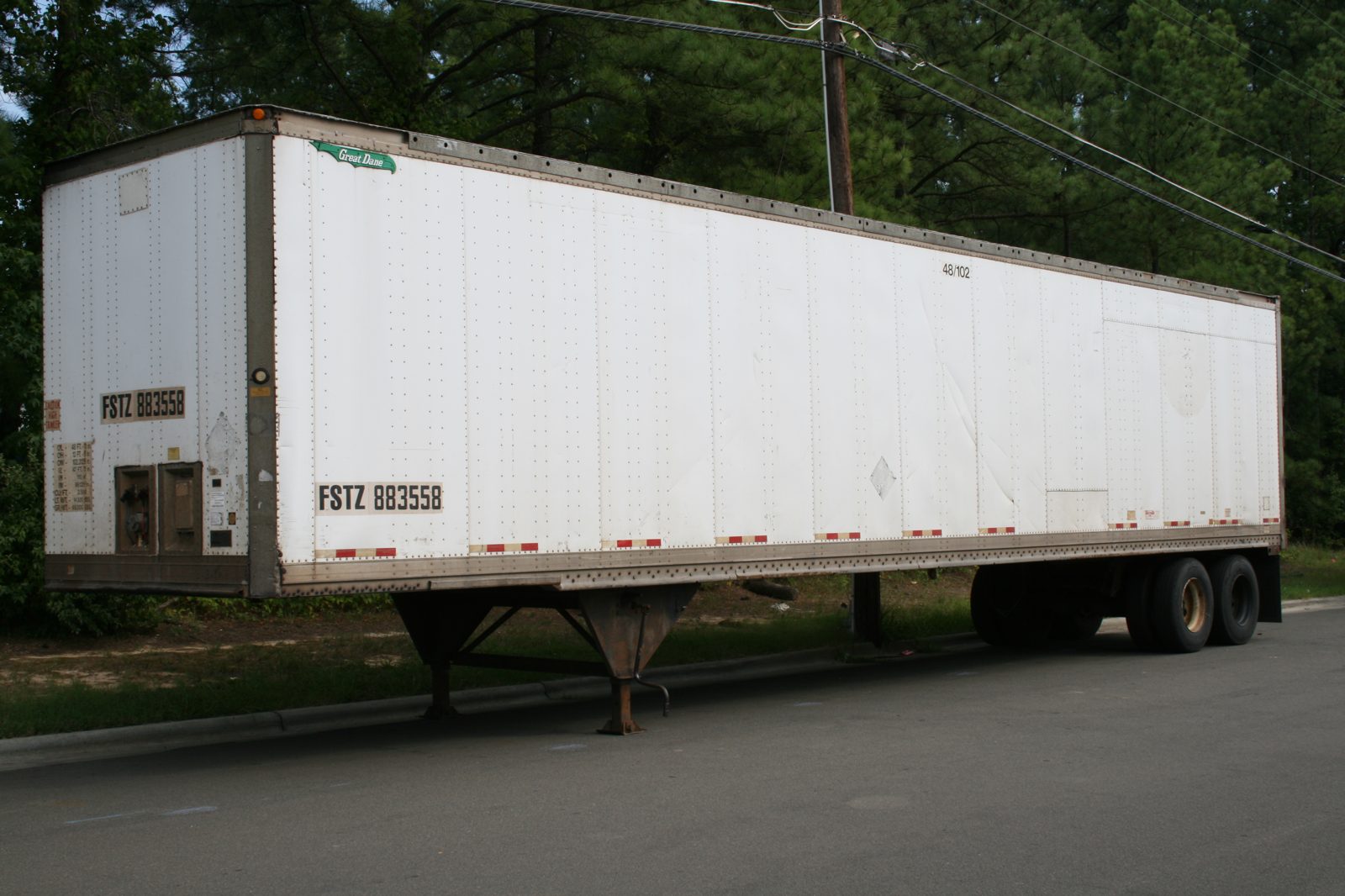 White dry van semi trailer parked on pavement